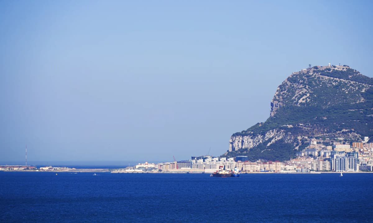 Scenic view of the iconic Rock of Gibraltar, with clear blue sky and sea, ideal for travel imagery.